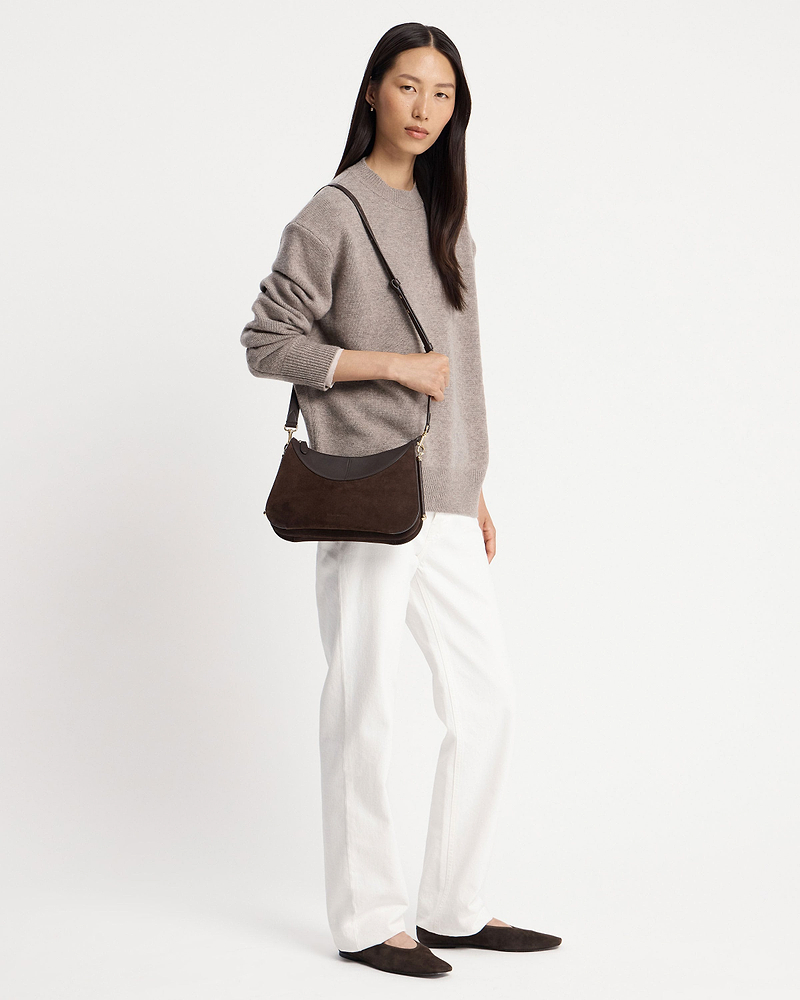 Model wearing an espresso suede shoulder bag over her shoulder.