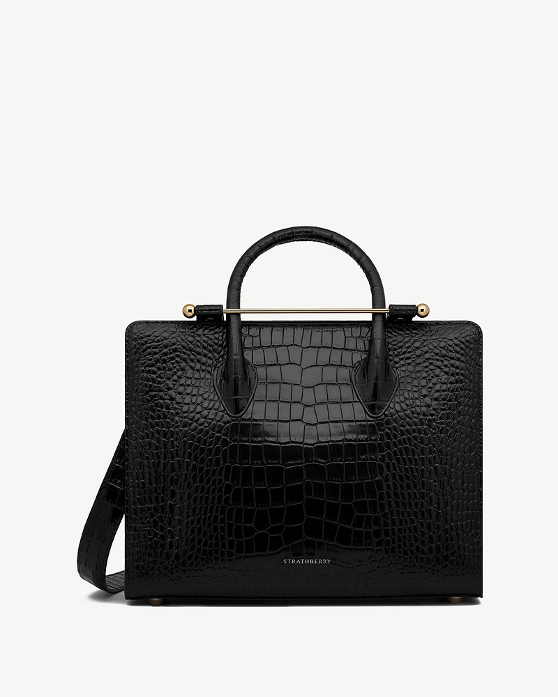 Strathberry midi tote in black croc-embossed leather with top handles, shoulder strap and gold bar