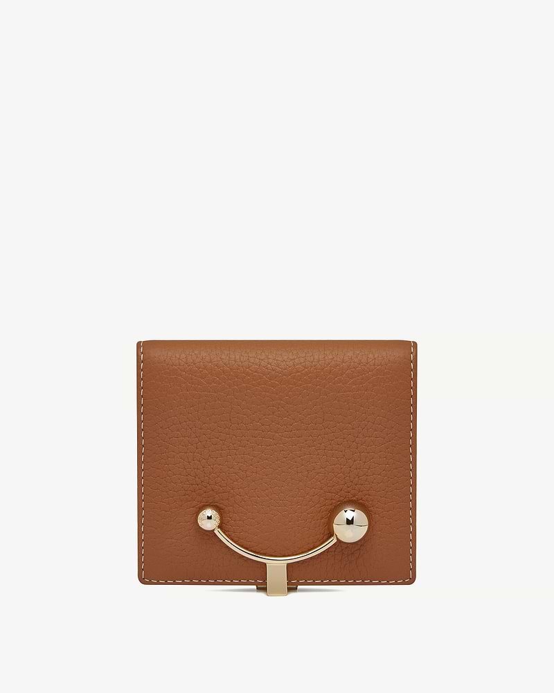 Tan leather crescent wallet with vanilla-coloured stitching and crescent-shaped gold bar closure.