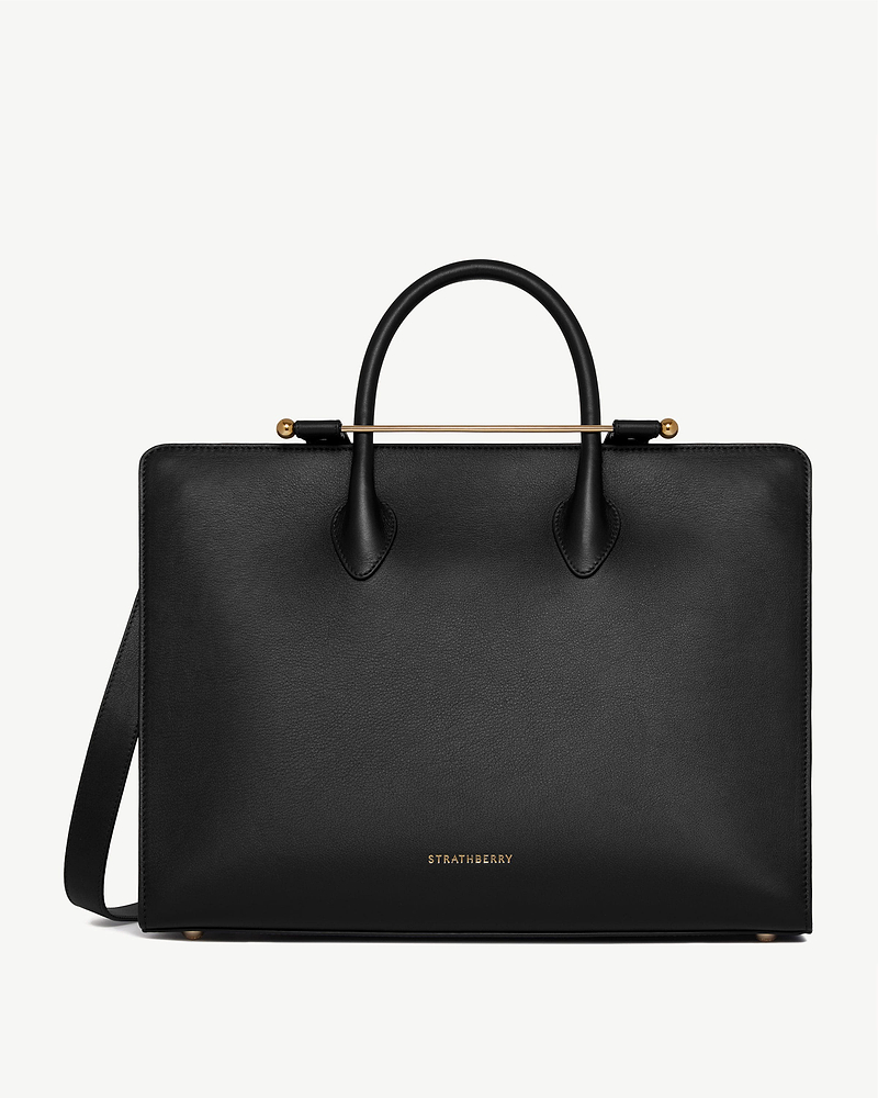 Black leather Strathberry structured tote with rounded handles and gold bar detail.