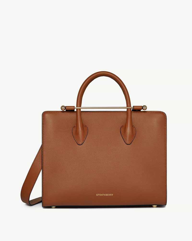 Chestnut leather midi tote with top handles, shoulder strap, gold bar detail and Strathberry logo.