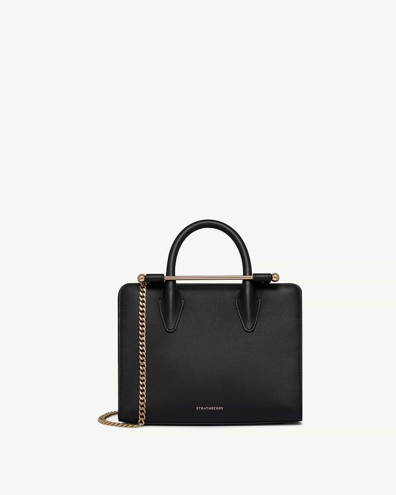 Black Strathberry mini tote with top handles, gold bar closure and chain strap.