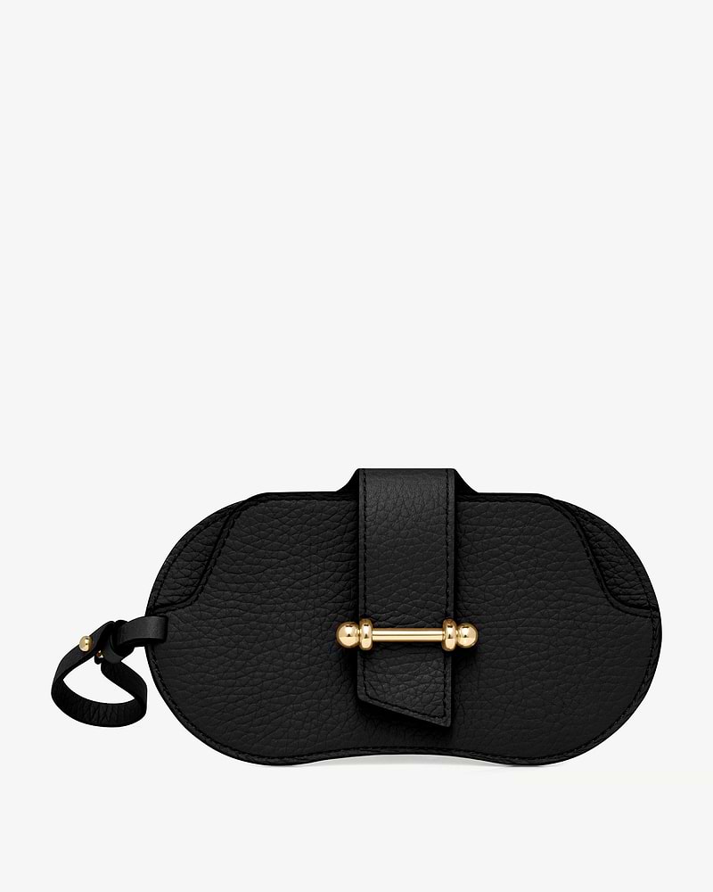 Black pebbled leather sunglasses case with gold bar closure and leather wrist strap