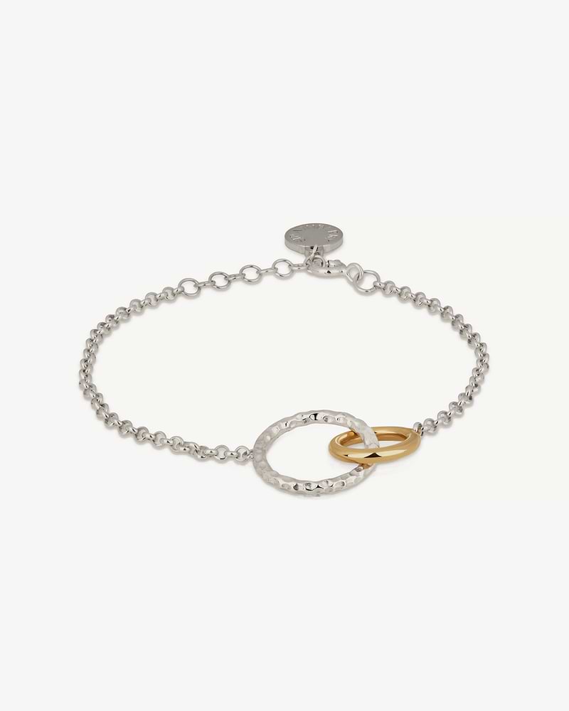 Sterling silver chain bracelet with hammered halo and two 24-carat gold-gilded rings.