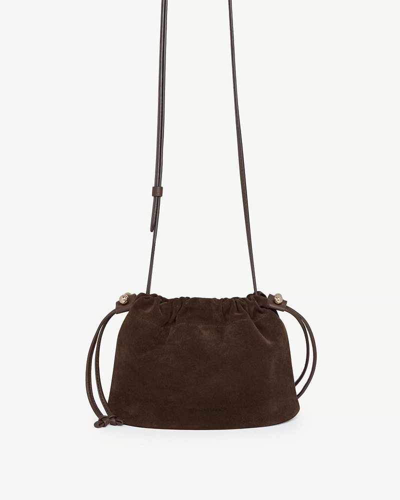 Chocolate suede Strathberry Charlotte drawstring bag with long strap and knotted ties.