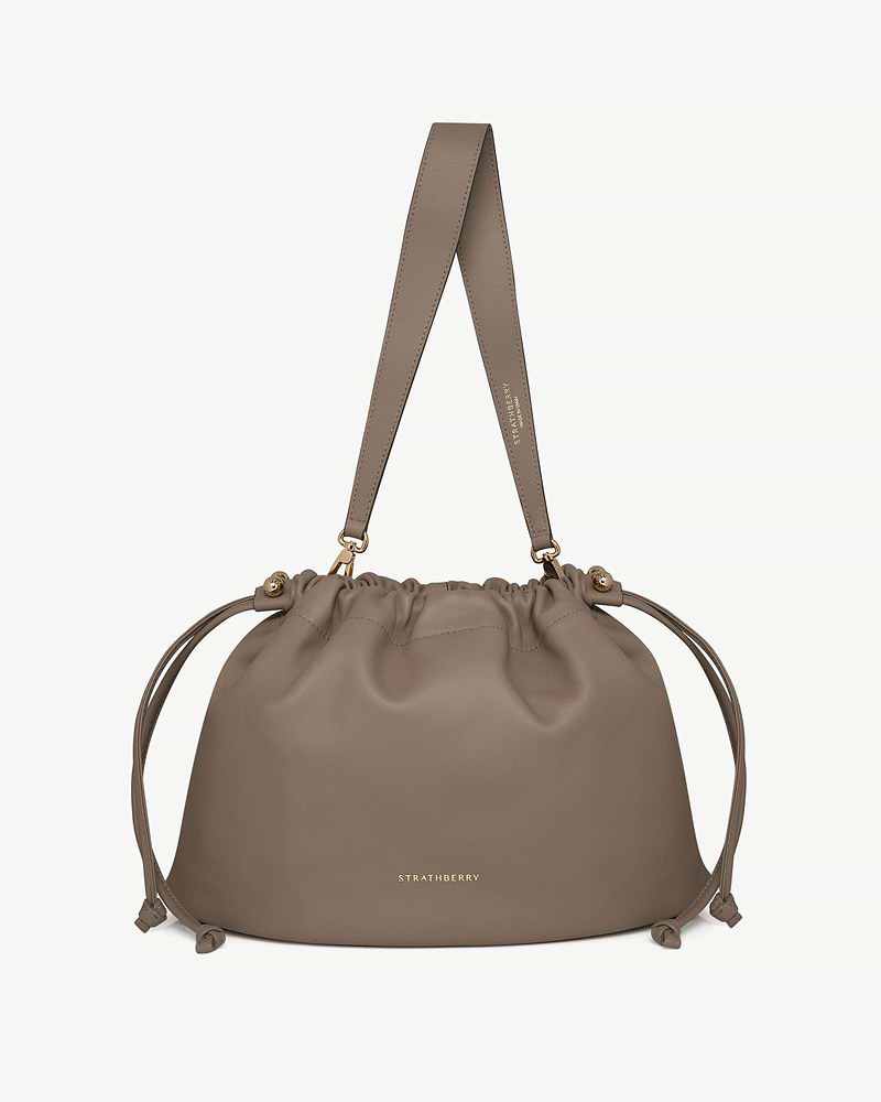 Taupe Charlotte Midi drawstring bag with shoulder strap and gold Strathberry logo
