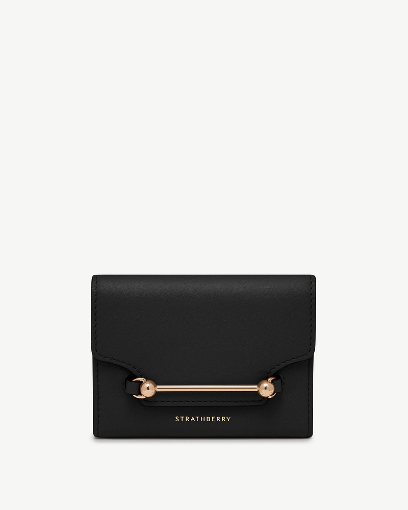 Strathberry black Multrees trifold wallet with gold bar hardware on front.