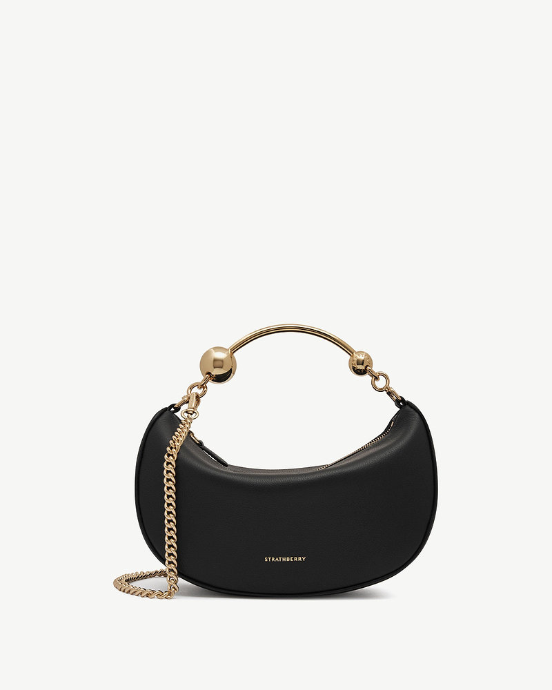 Strathberry Crescent Moon Mini black leather crescent bag with gold chain strap.