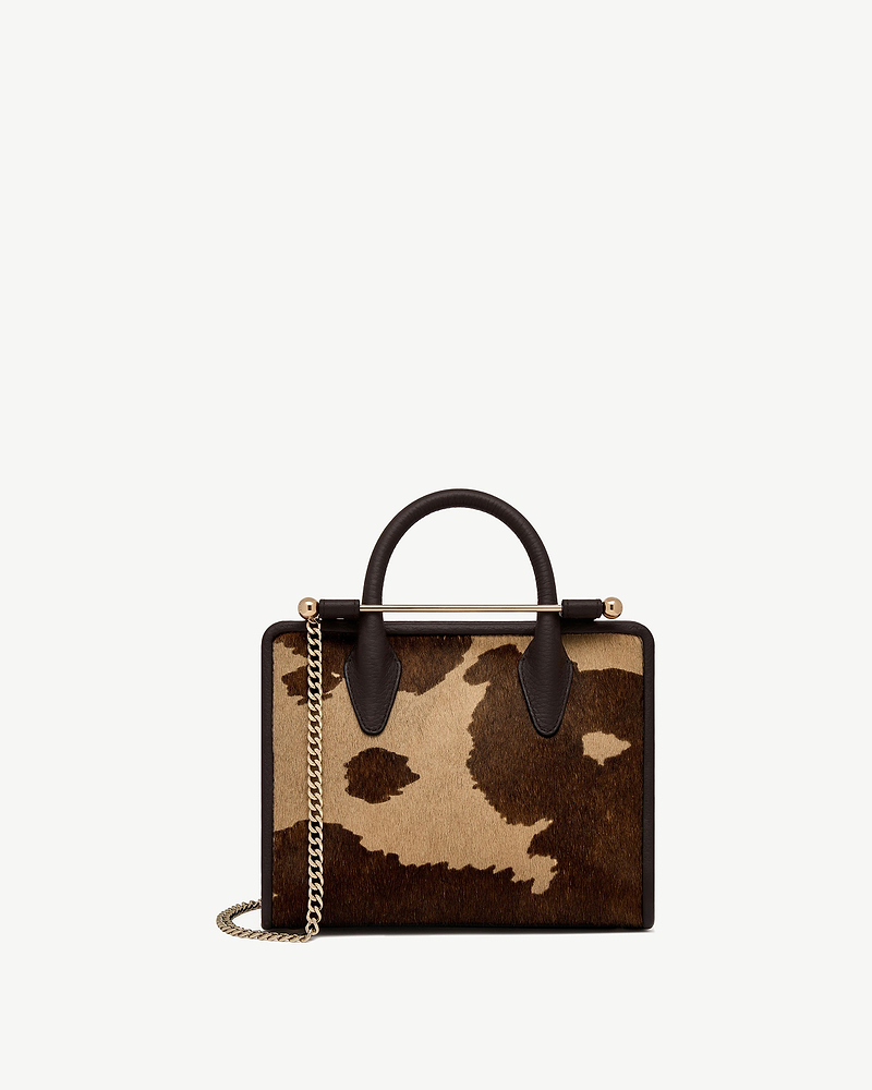 Mini tote in sand and espresso spot print with top handle and chain.