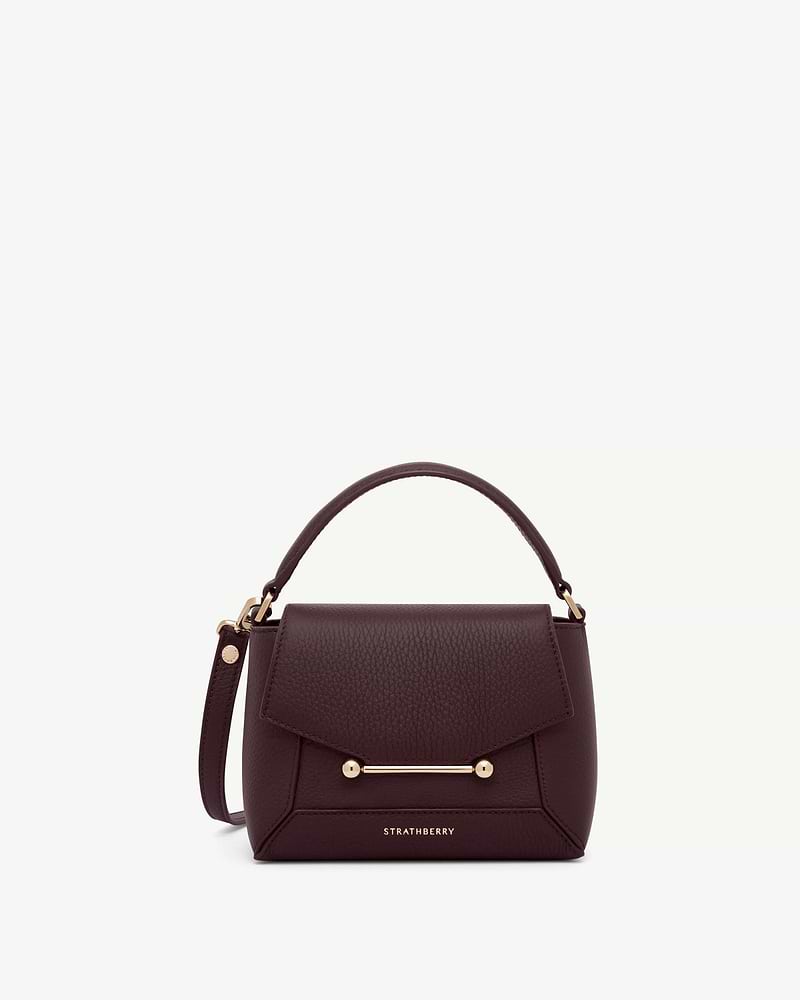 Strathberry burgundy Mosaic Nano bag with top handle, strap and gold bar.