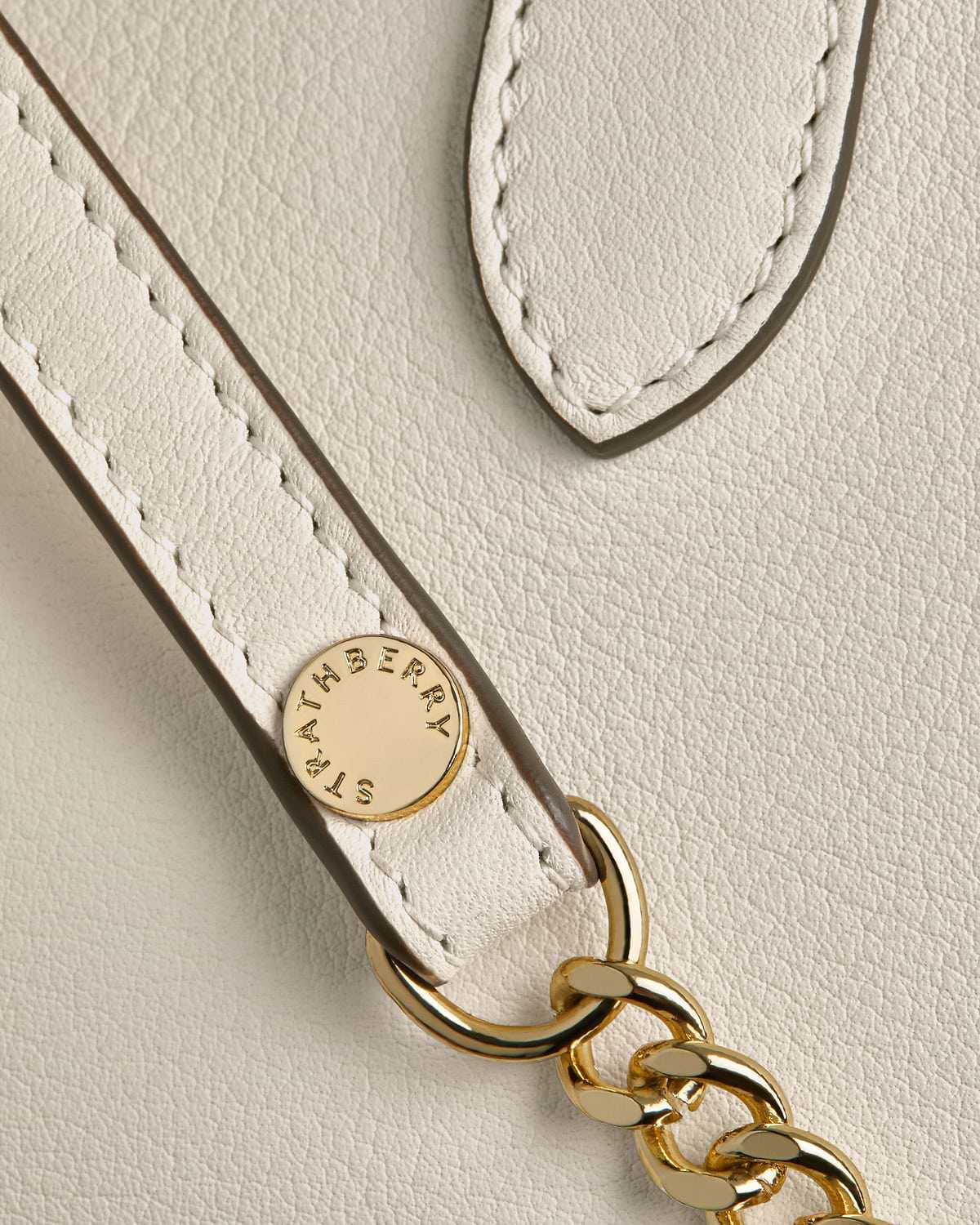 Vanilla leather nano tote strap with gold chain and Strathberry rivet.