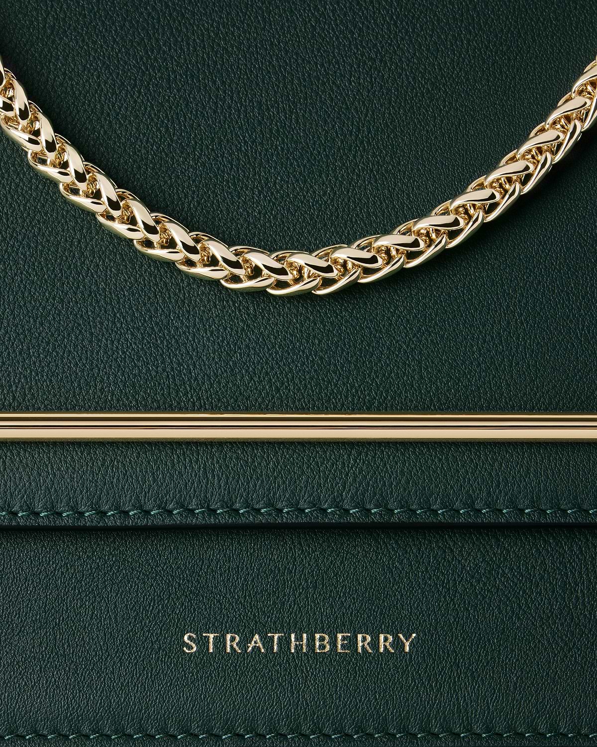 Bottle green leather bag detail with gold chain and Strathberry logo.