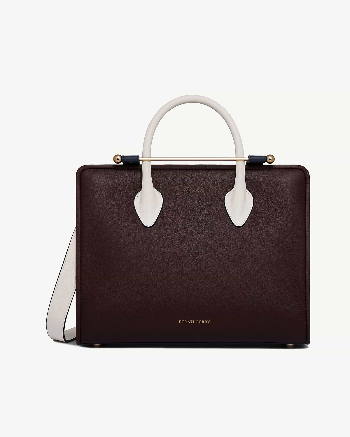 Front of burgundy midi tote with vanilla-coloured handles, navy bar and Strathberry logo.