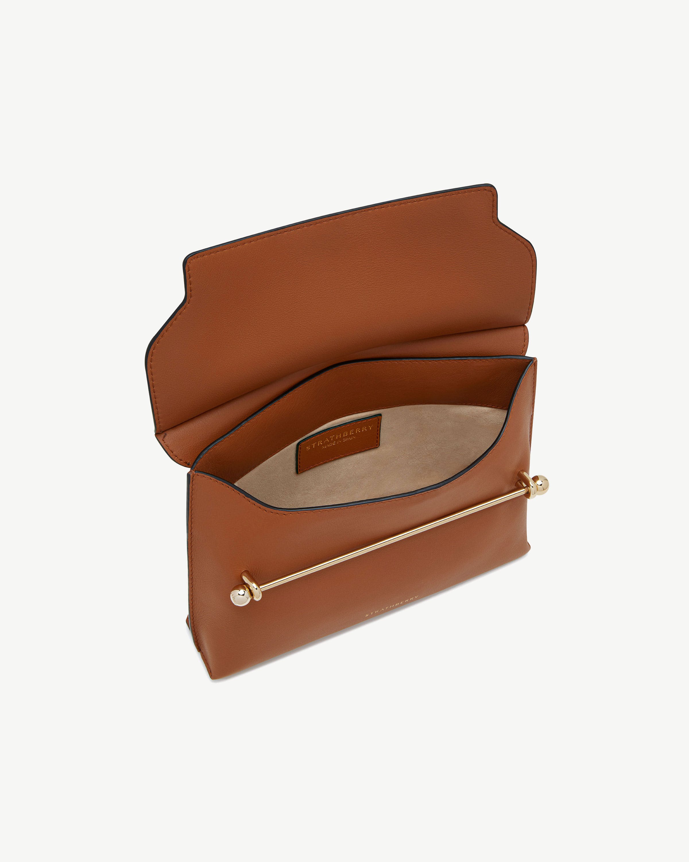 Chestnut Stylist leather bag with flap open, gold bar detail and Strathberry label.