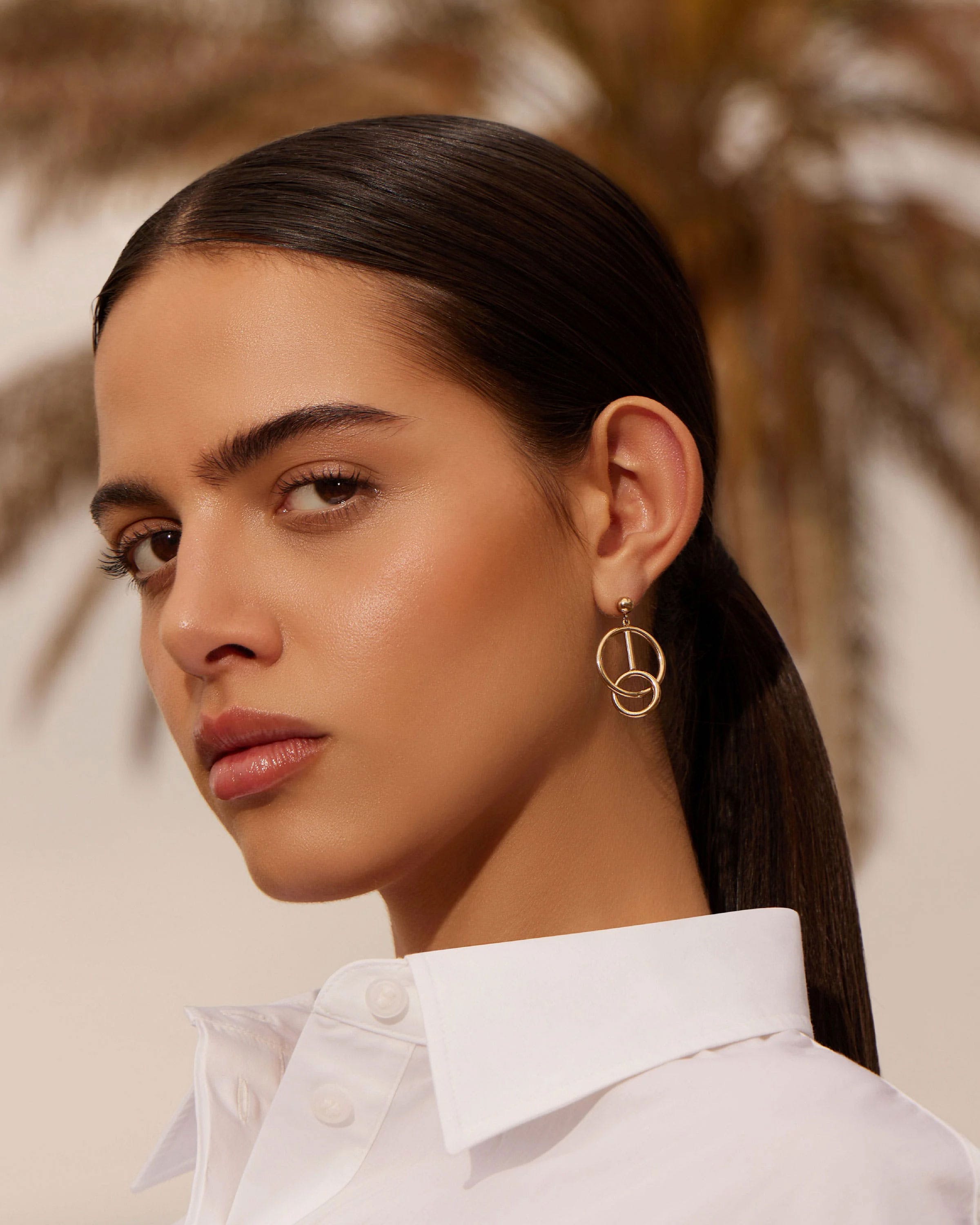 Model's right ear wearing 22-carat gold-gilded music bar hoop earring