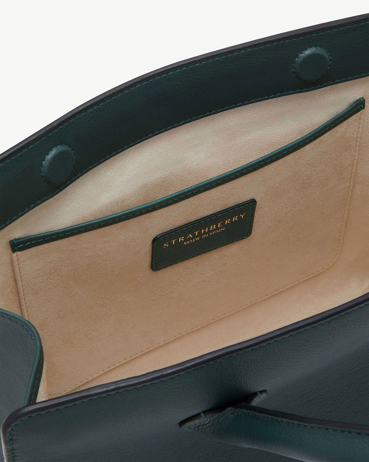 Bottle green leather midi tote interior with beige suede lining and Strathberry label.
