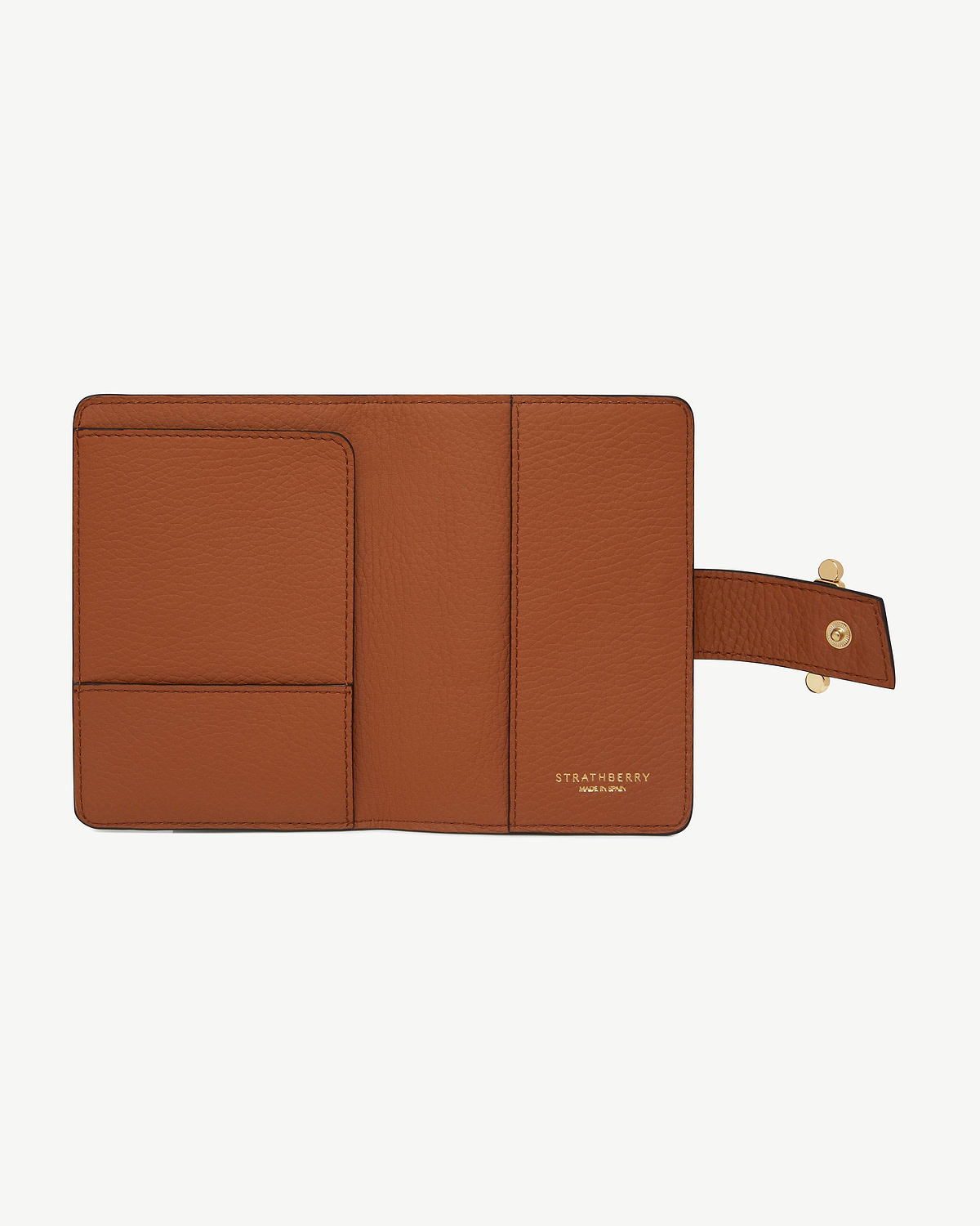 Open tan Strathberry passport holder with card slots and snap strap.