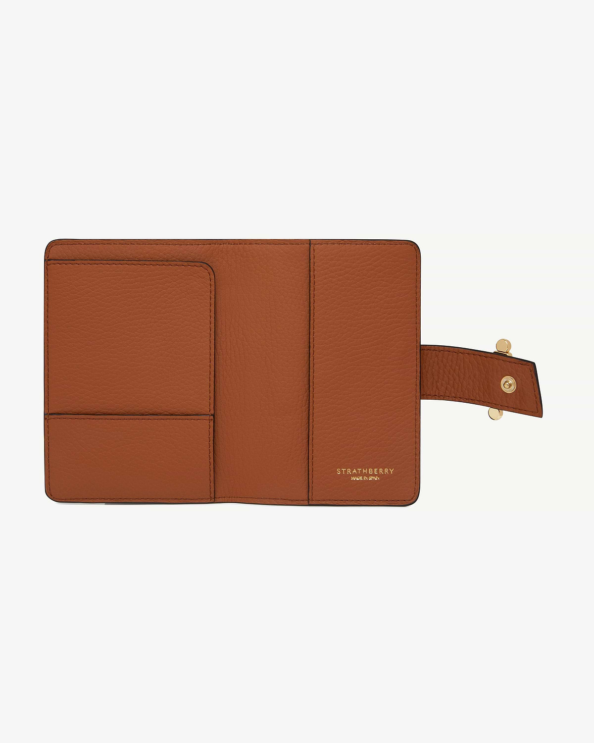 Open tan Strathberry passport holder with card slots and snap strap.