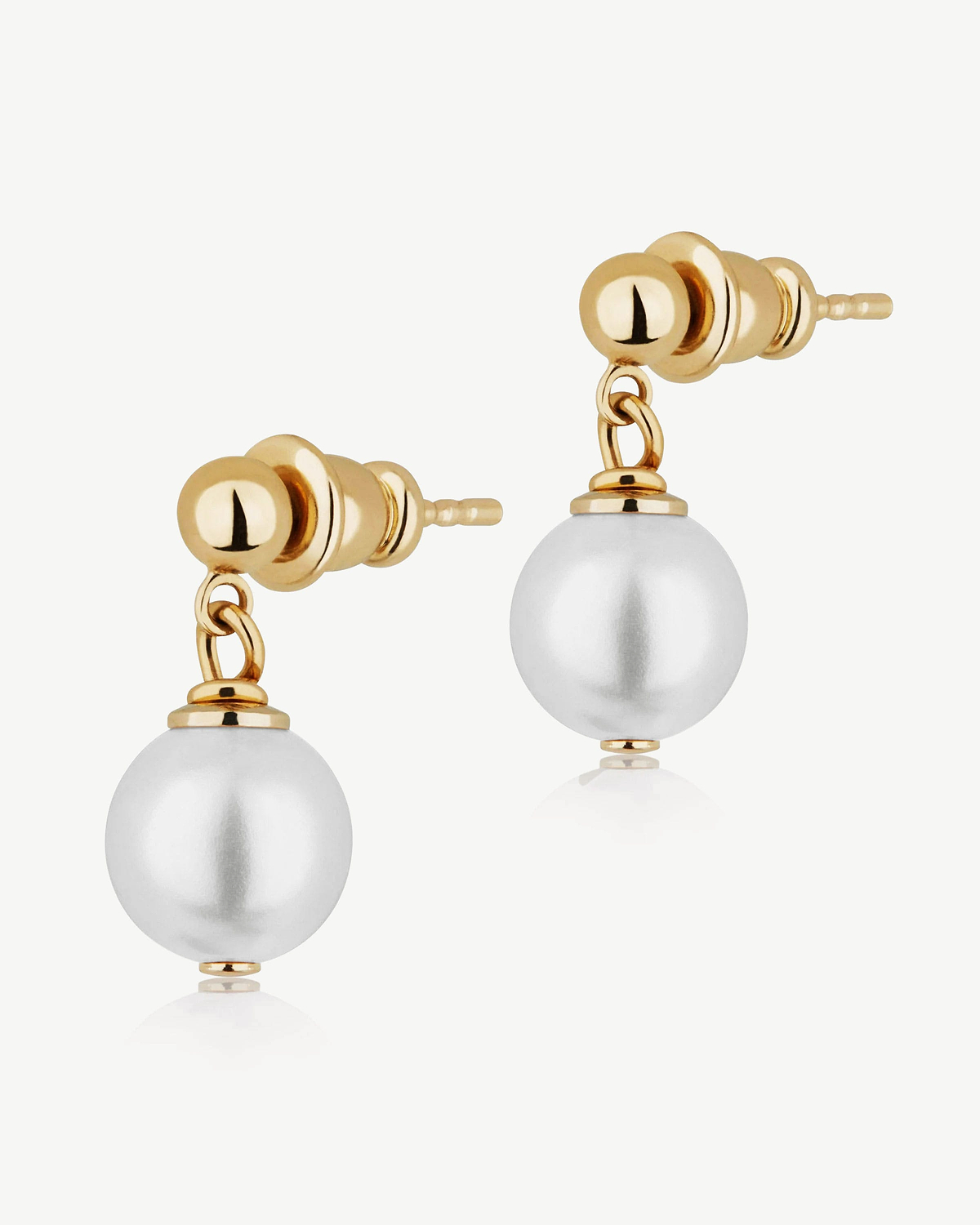 Pair of 24 carat gold-gilded stud earrings with single white pearl drops on white background.