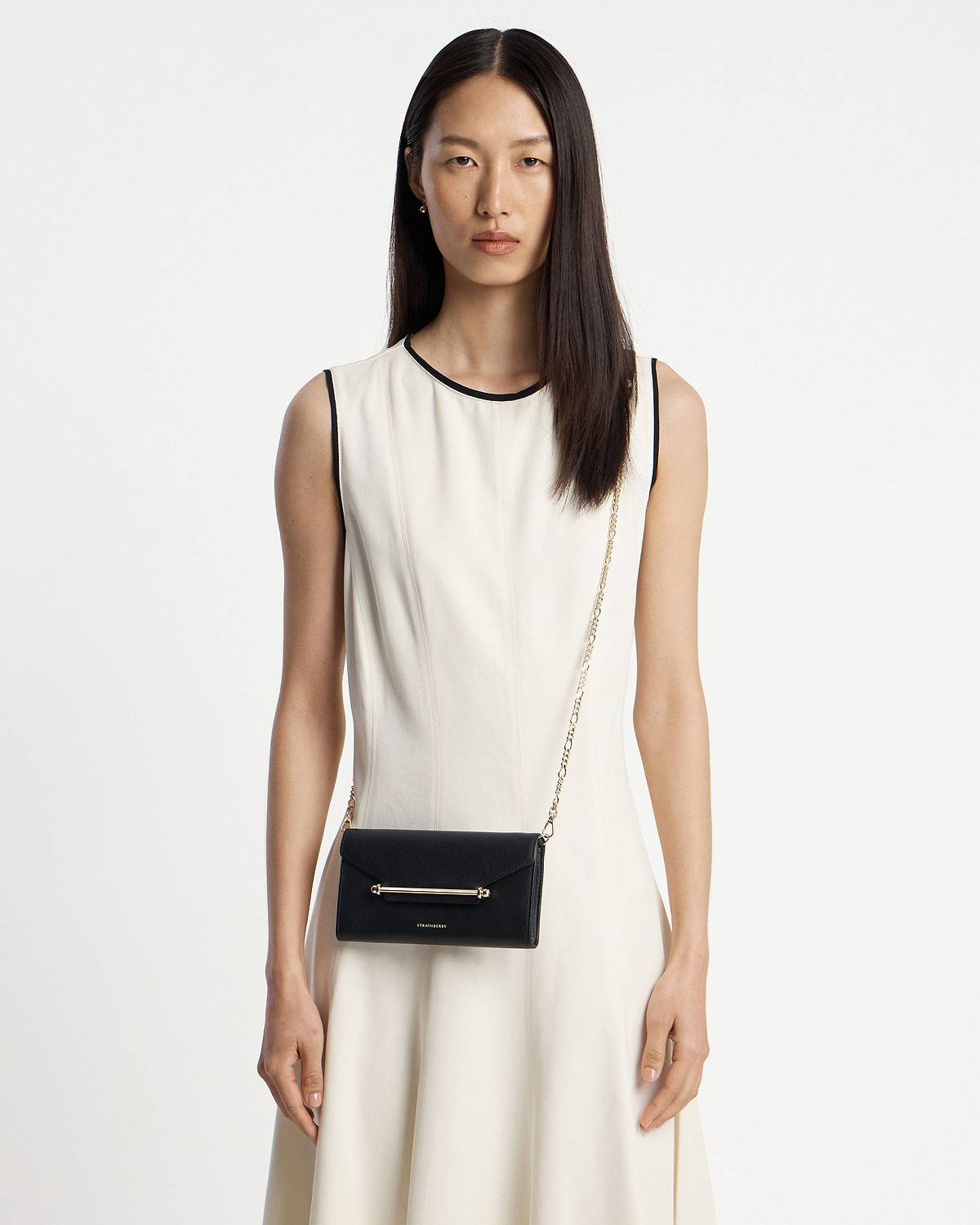 Model wearing black Multrees chain wallet with gold bar and chain strap