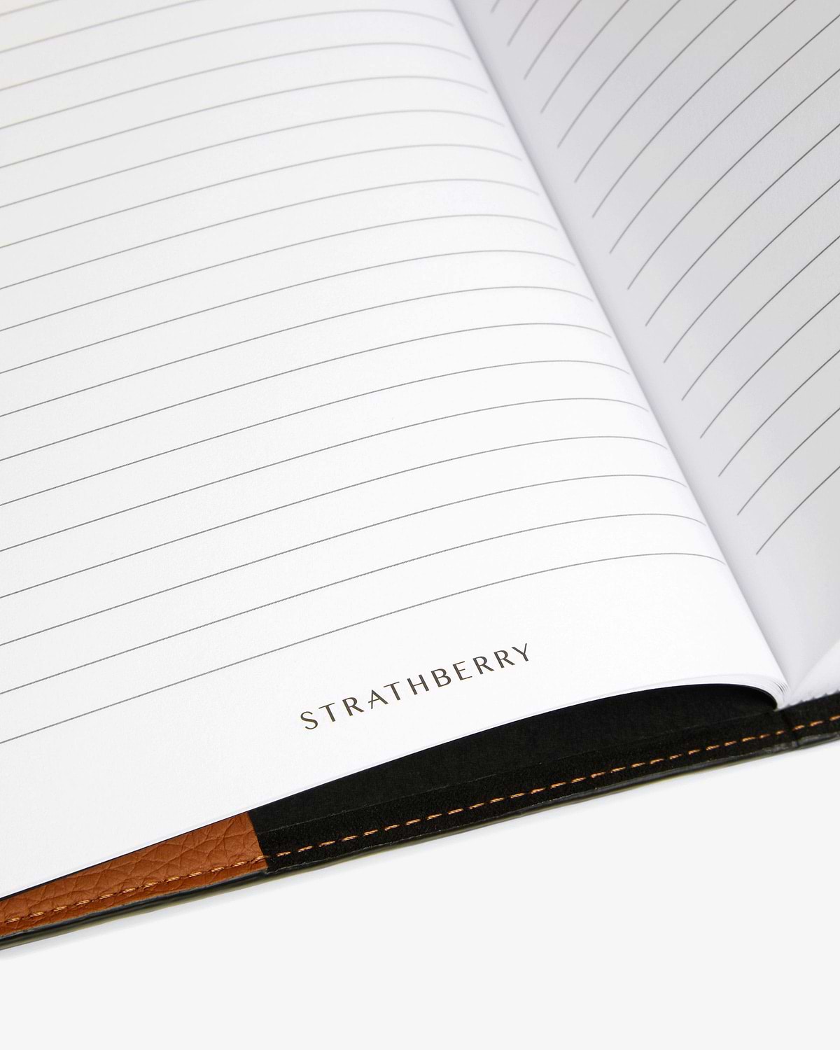 Open lined notebook pages showing STRATHBERRY logo and tan leather spine.