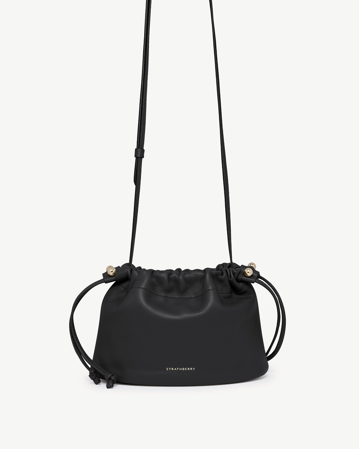 Black Strathberry Charlotte drawstring bag with long shoulder strap and gold hardware.