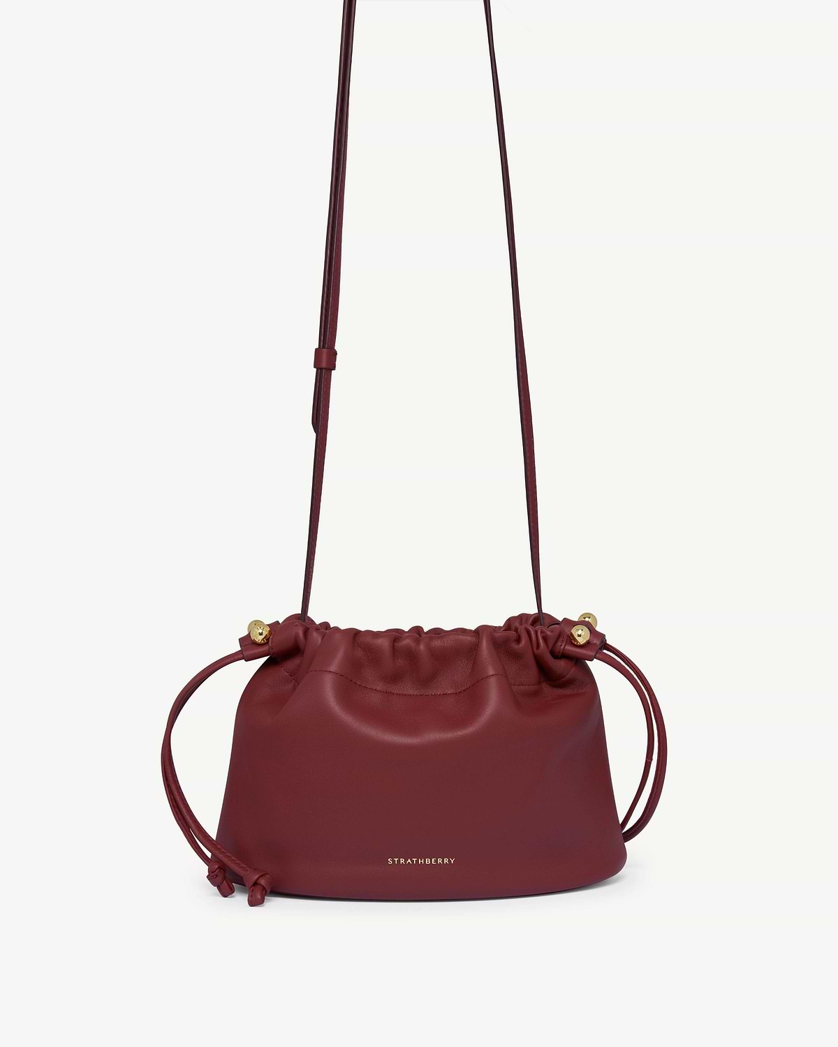 Oxblood Strathberry Charlotte drawstring bag with long strap and gold fittings.