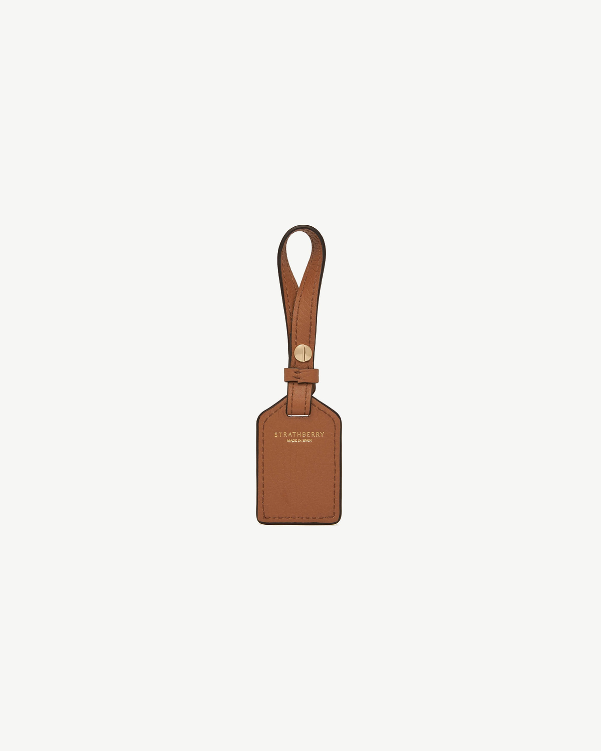 Tan leather tag with strap, gold rivet and Strathberry logo.