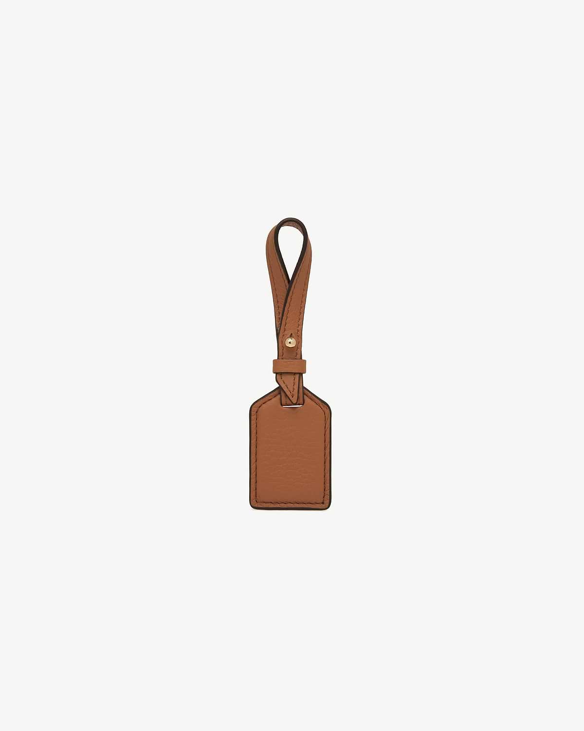 Tan rectangular leather tag with stitched edges and loop strap.