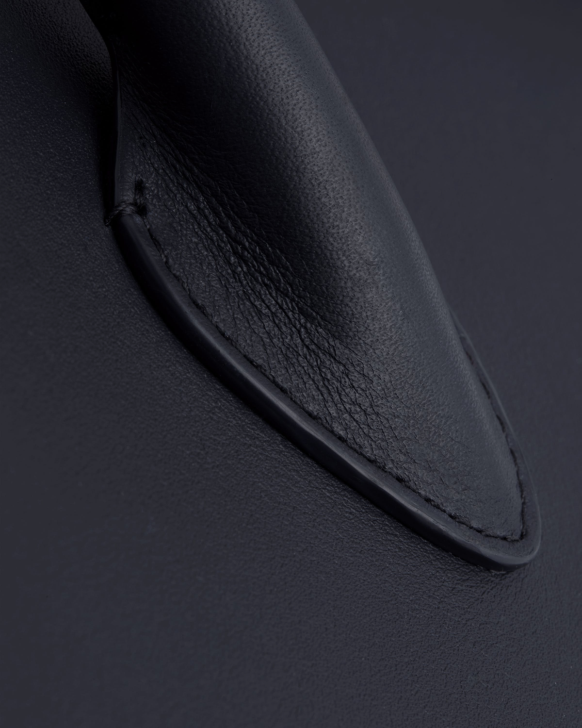 Close-up of stitched handle base on marine blue midi tote.