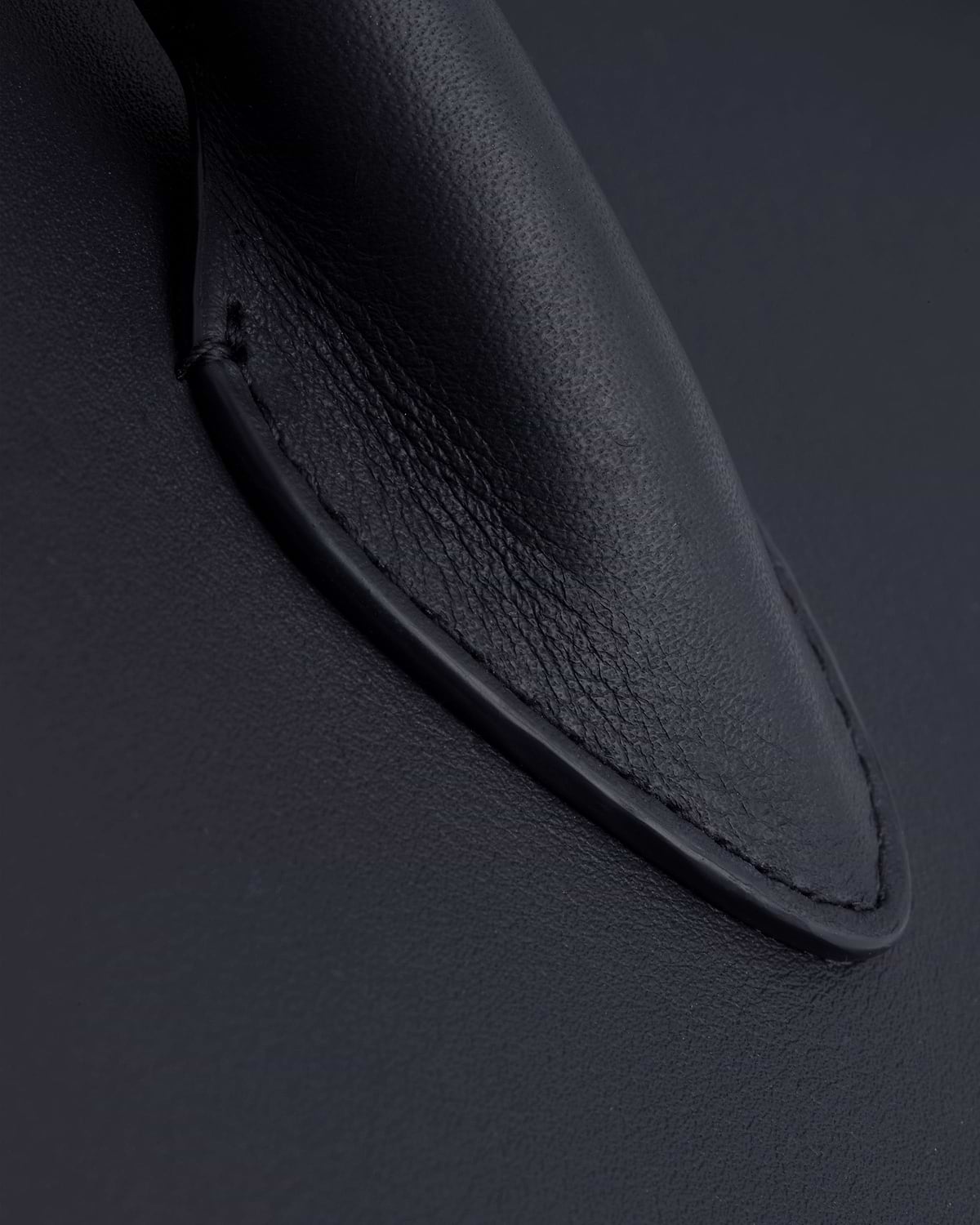 Close-up of stitched handle base on marine blue midi tote.