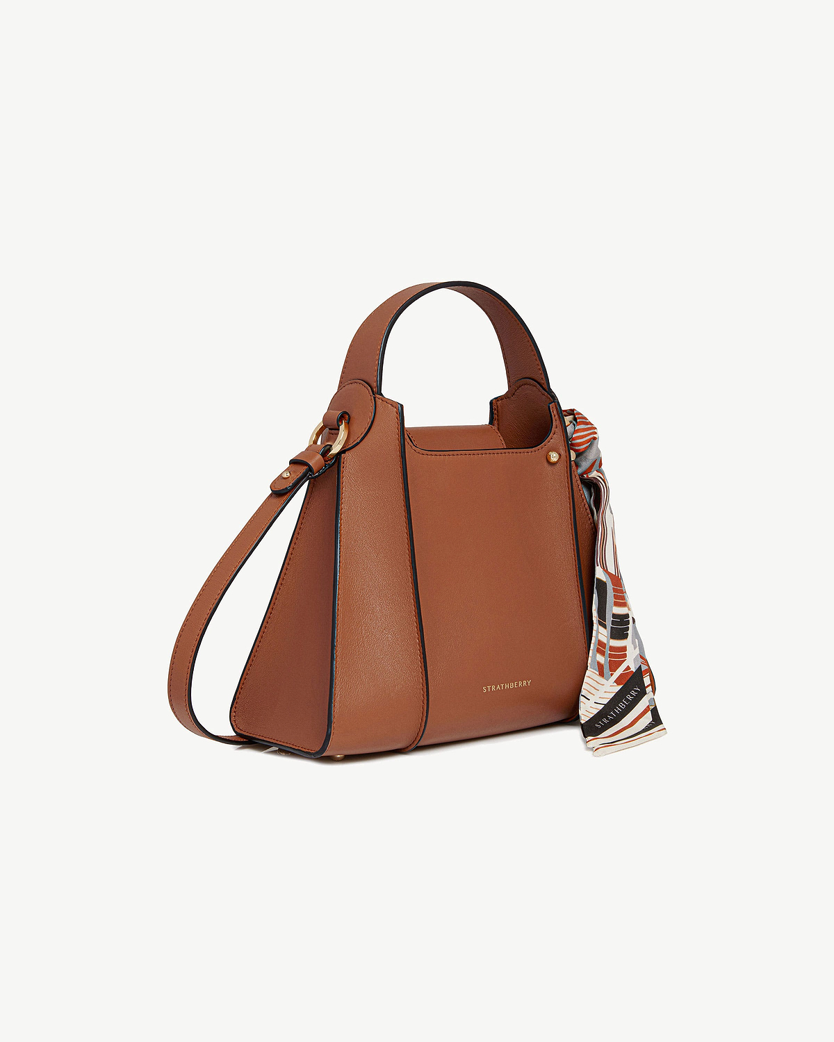 Tan Arkshell Strathberry handbag with top handle, shoulder strap, patterned scarf and gold hardware.