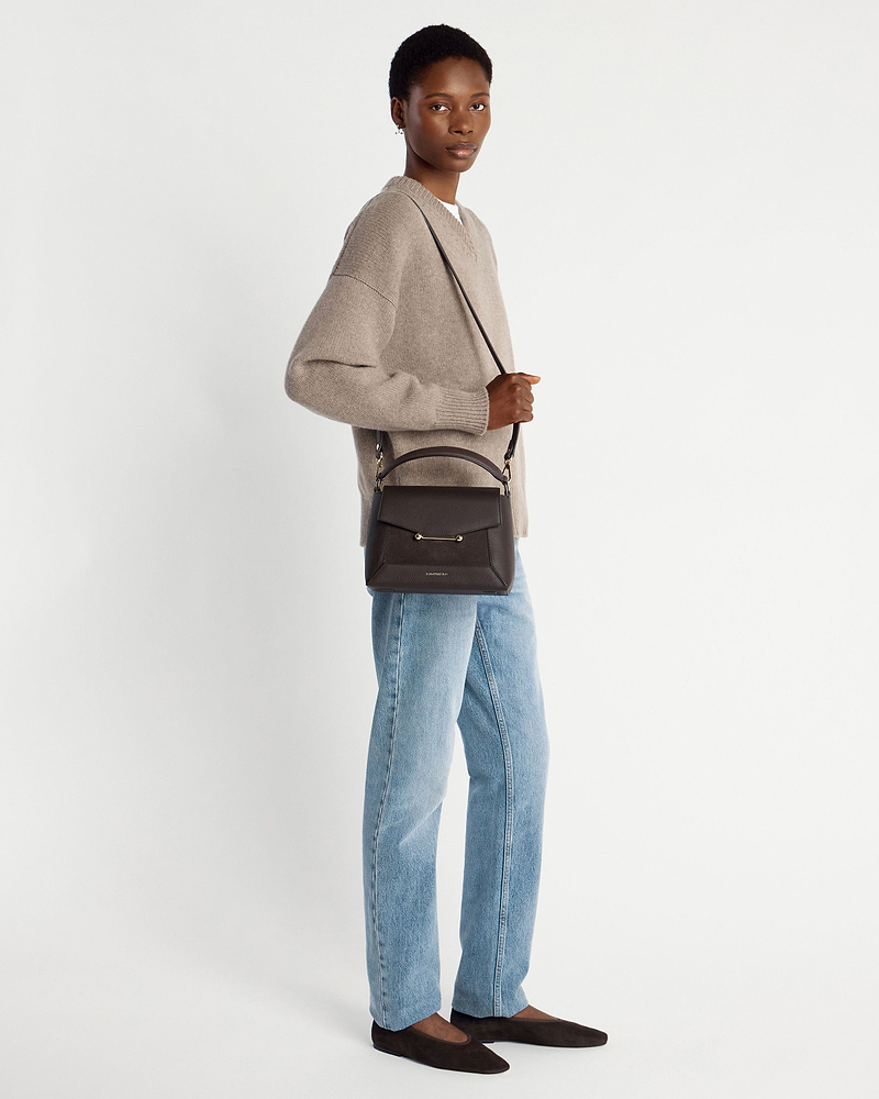 Woman wearing beige jumper and jeans carrying dark chocolate suede and leather mosaic bag.