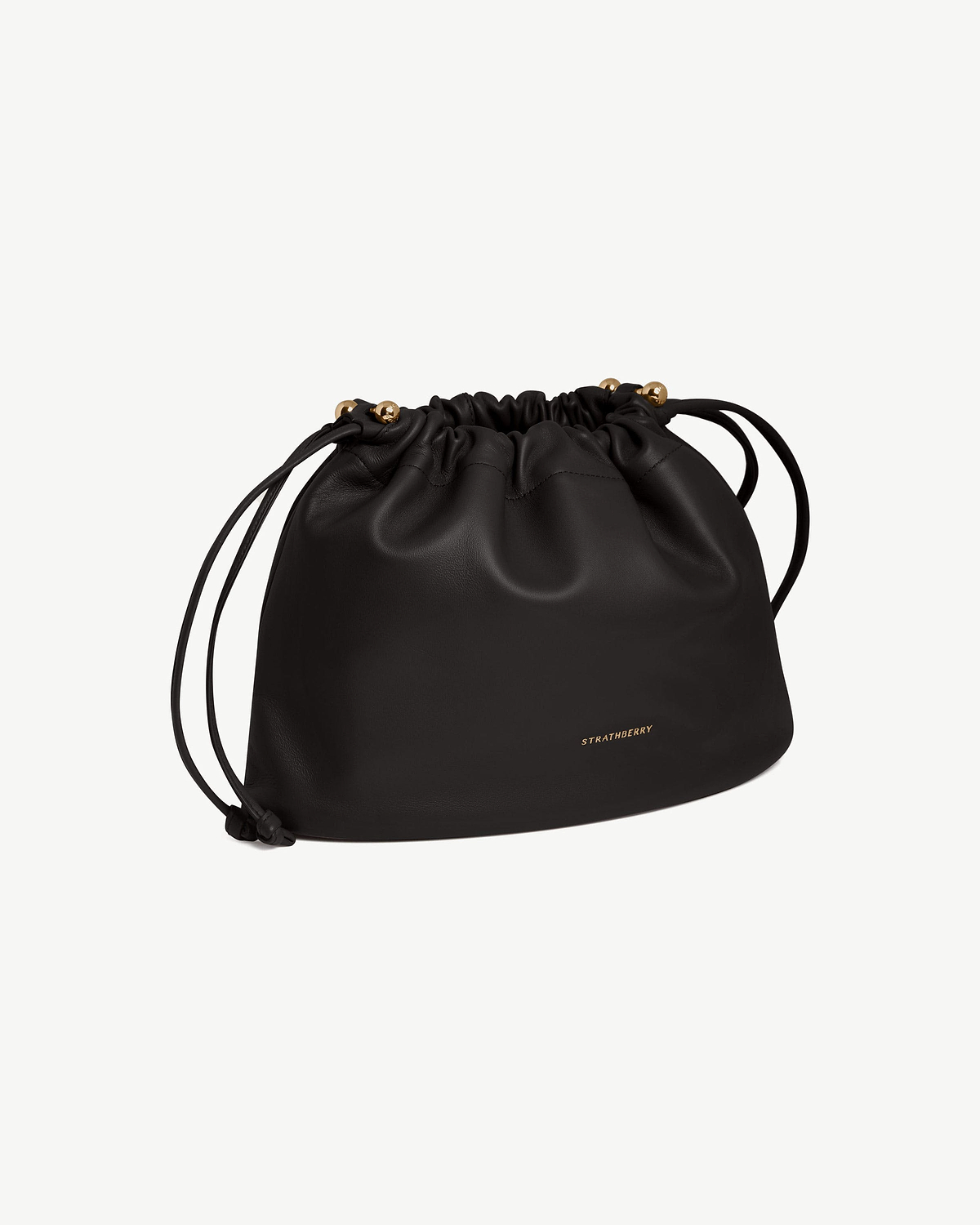 Black Strathberry Charlotte Midi drawstring bag with front logo and gold-tone bead details.