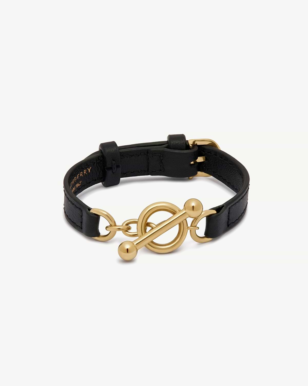 Black leather bracelet with gold circular toggle and bar fastening.