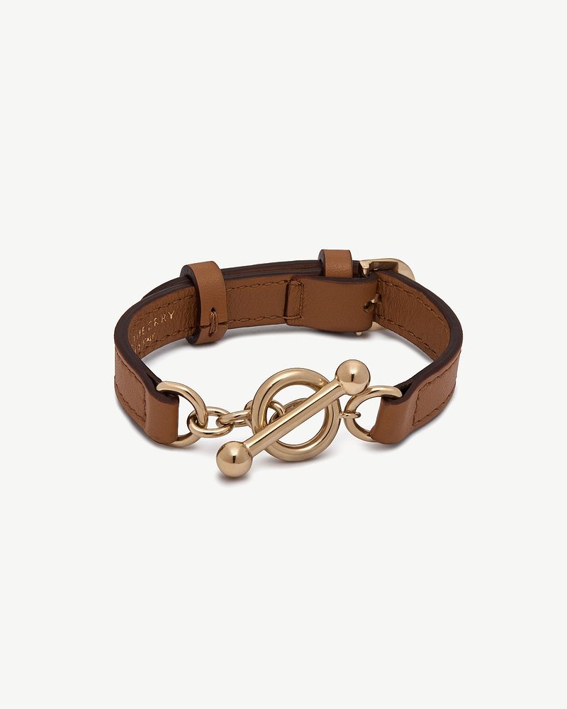 Tan leather bracelet with gold circular toggle clasp and adjustable buckle