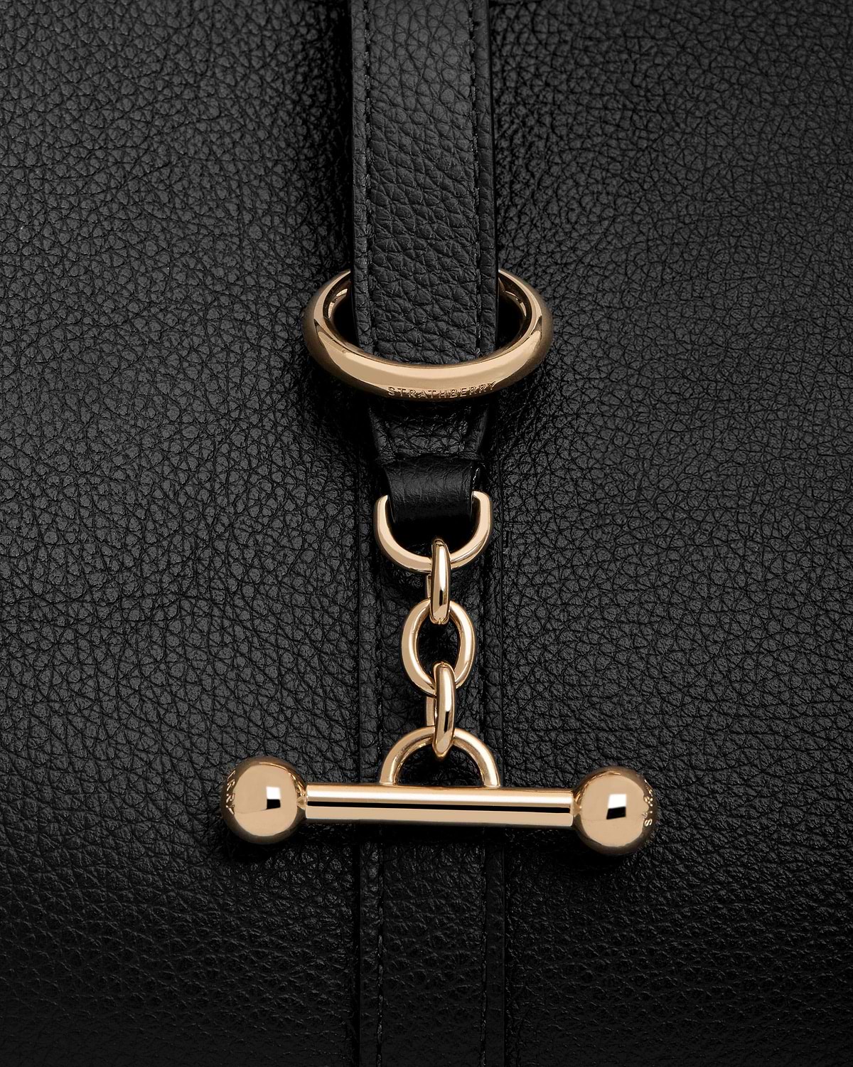 Black pebbled leather with gold Strathberry bar toggle fastening and chain detail