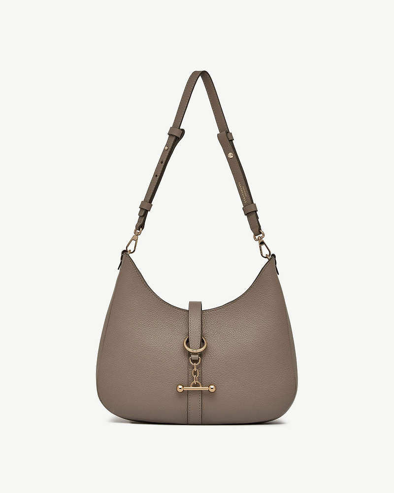 Taupe pebbled leather kite sling bag with adjustable strap and gold bar hardware.