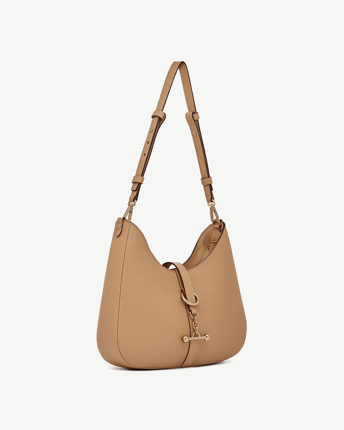 Caramel leather kite sling bag with single adjustable strap and metal clasp.