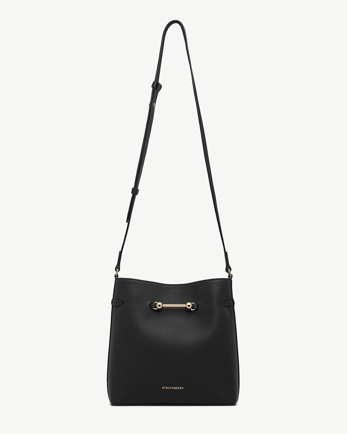 Black Corda bucket bag with adjustable shoulder strap, gold bar hardware, Strathberry logo.