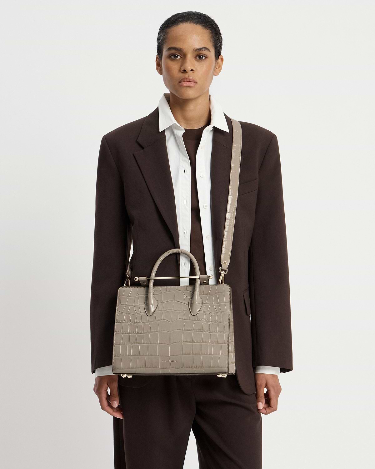 Model wearing Strathberry croc midi tote with top handles and shoulder strap