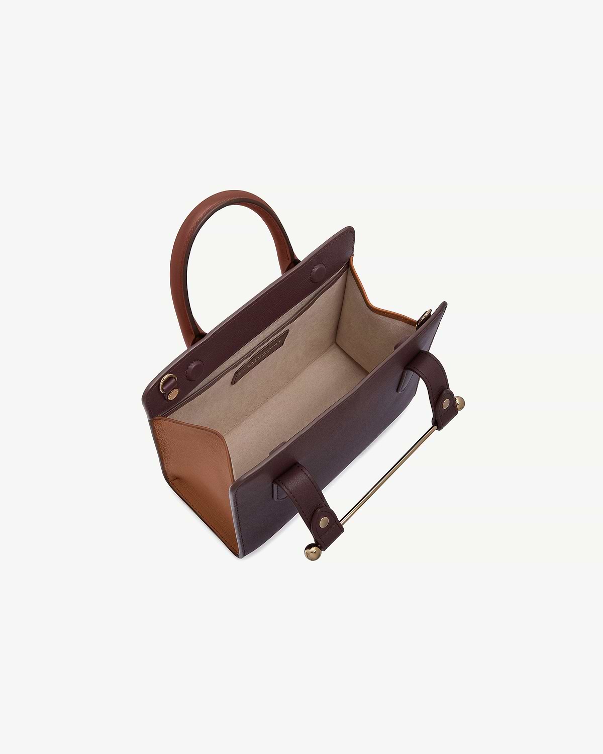 Mini tote with open interior, burgundy body, chestnut sides and walnut handles.