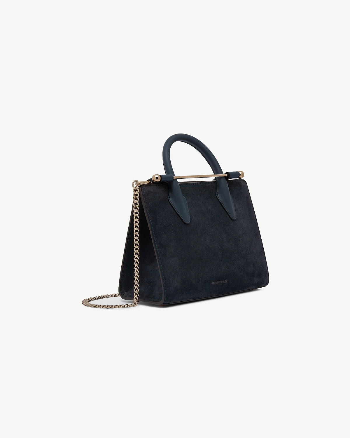 Strathberry navy suede mini tote with top handles, gold bar and chain strap.