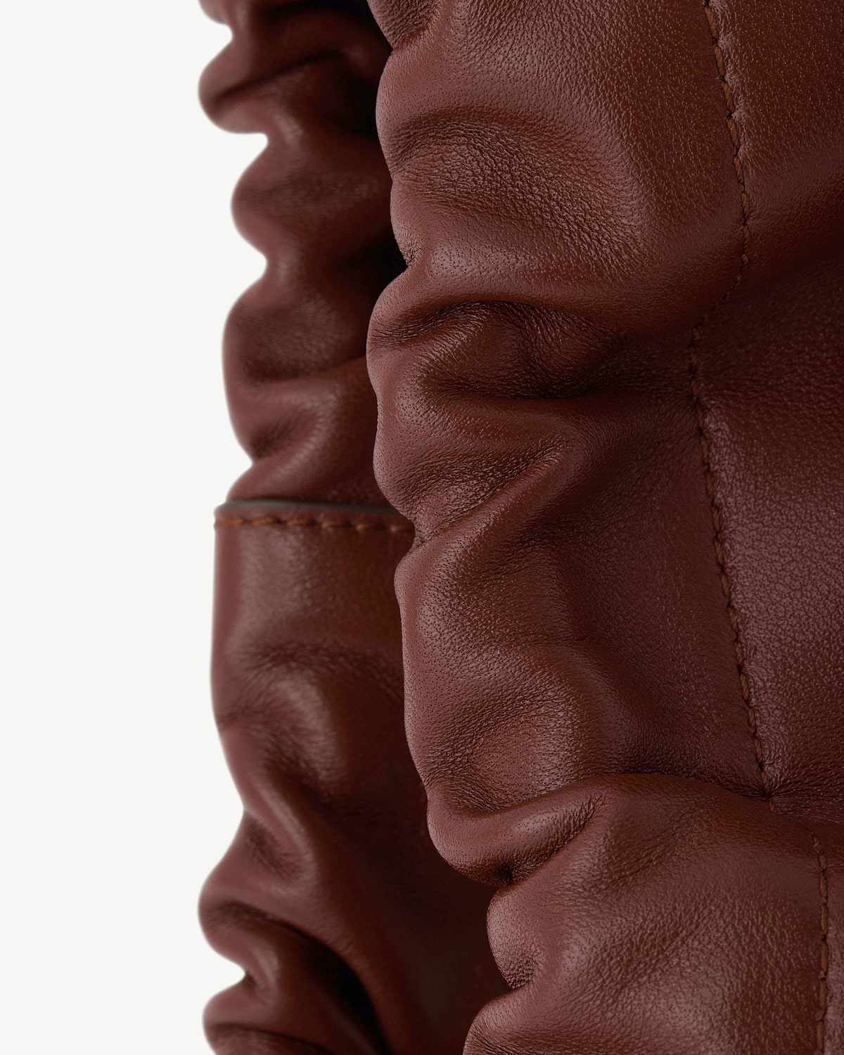 Close-up of walnut leather ruched drawstring detail with visible stitching.