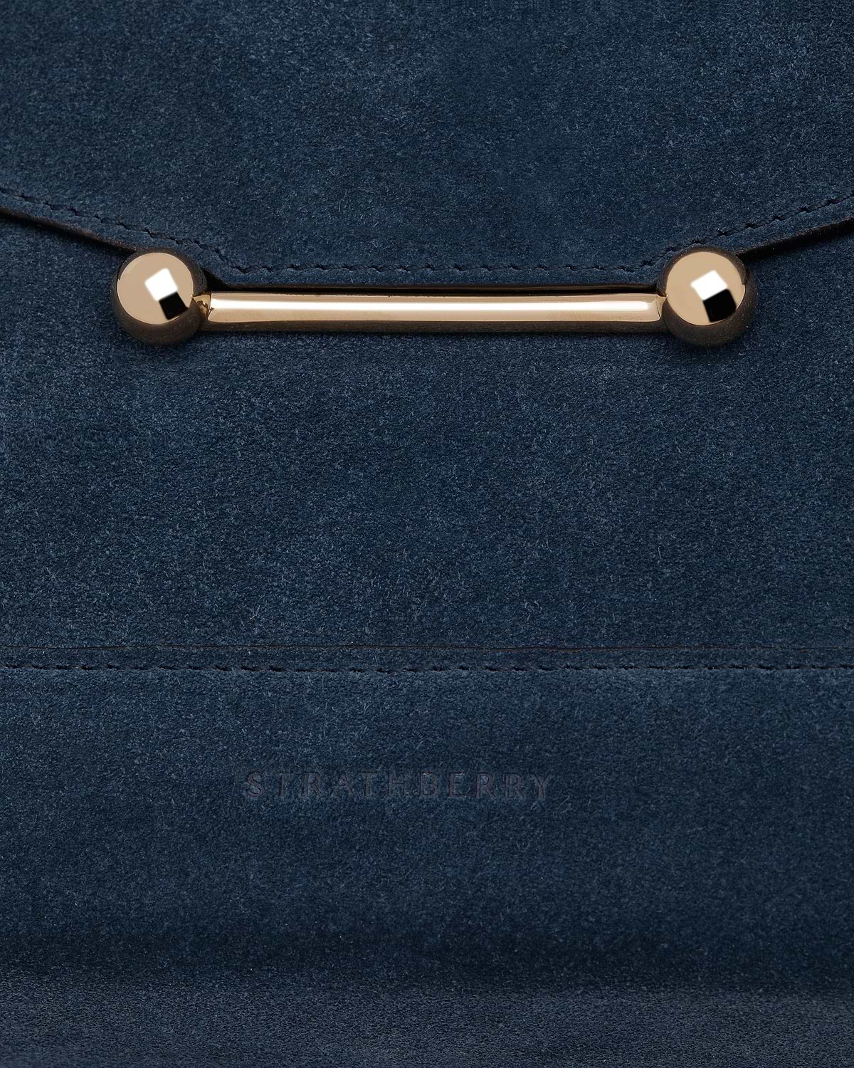 Loch blue suede mosaic bag close-up showing gold bar clasp and embossed Strathberry logo.