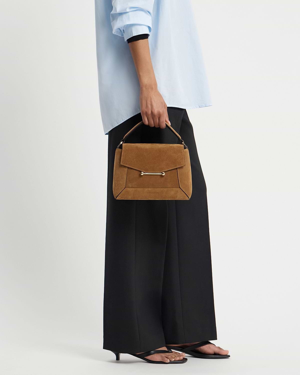 Model holding toffee suede mosaic bag with espresso trim and top handle.