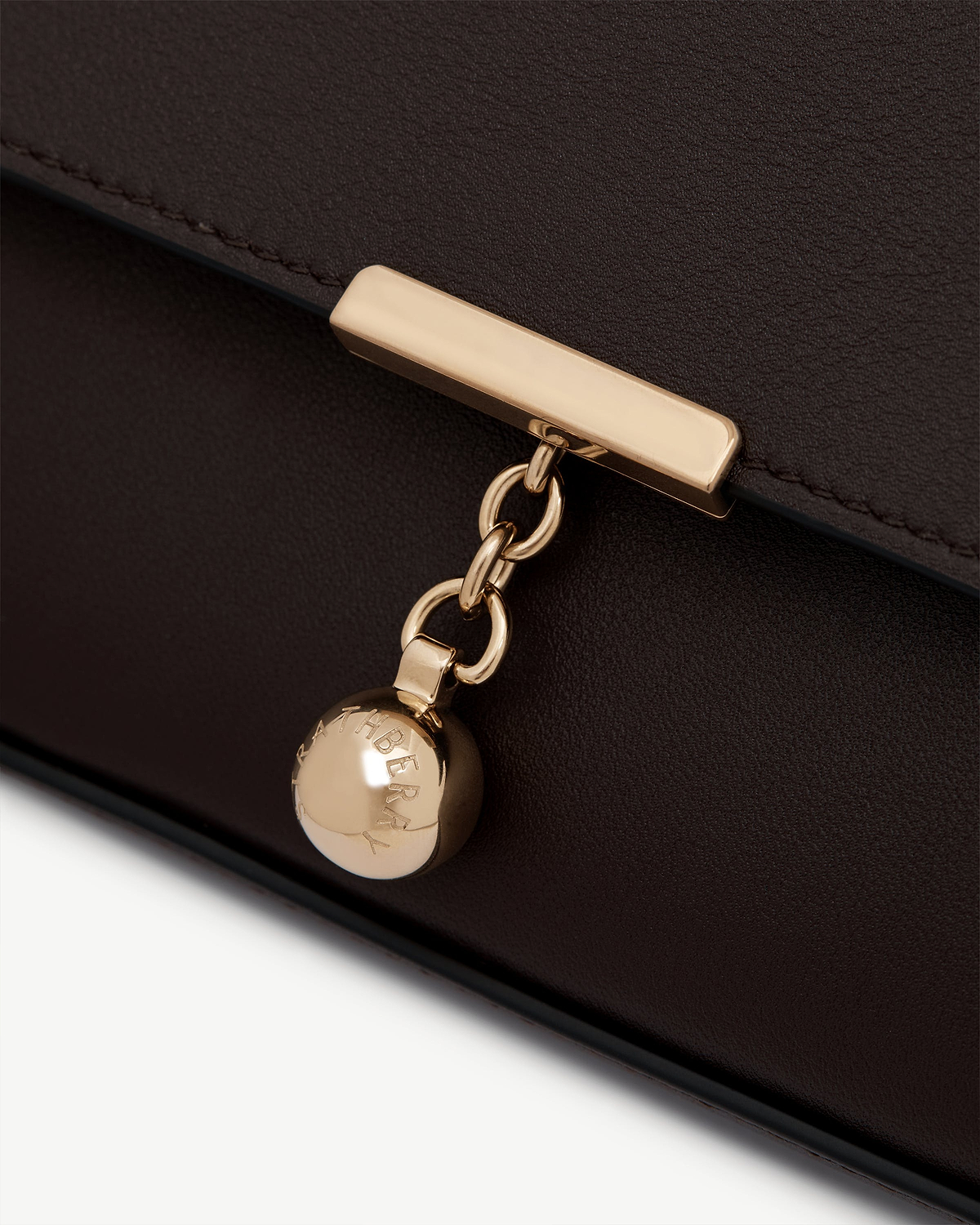 Espresso leather clutch clasp with gold chain and Strathberry engraved charm