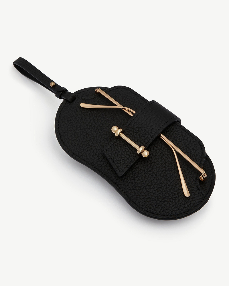 Black pebbled sunglasses case with strap and gold-tone bar hardware.