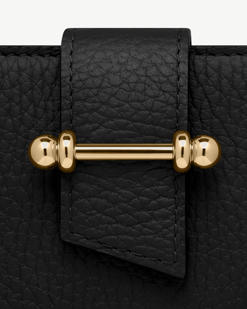 Black grained leather strap with visible stitching and gold bar hardware detail.