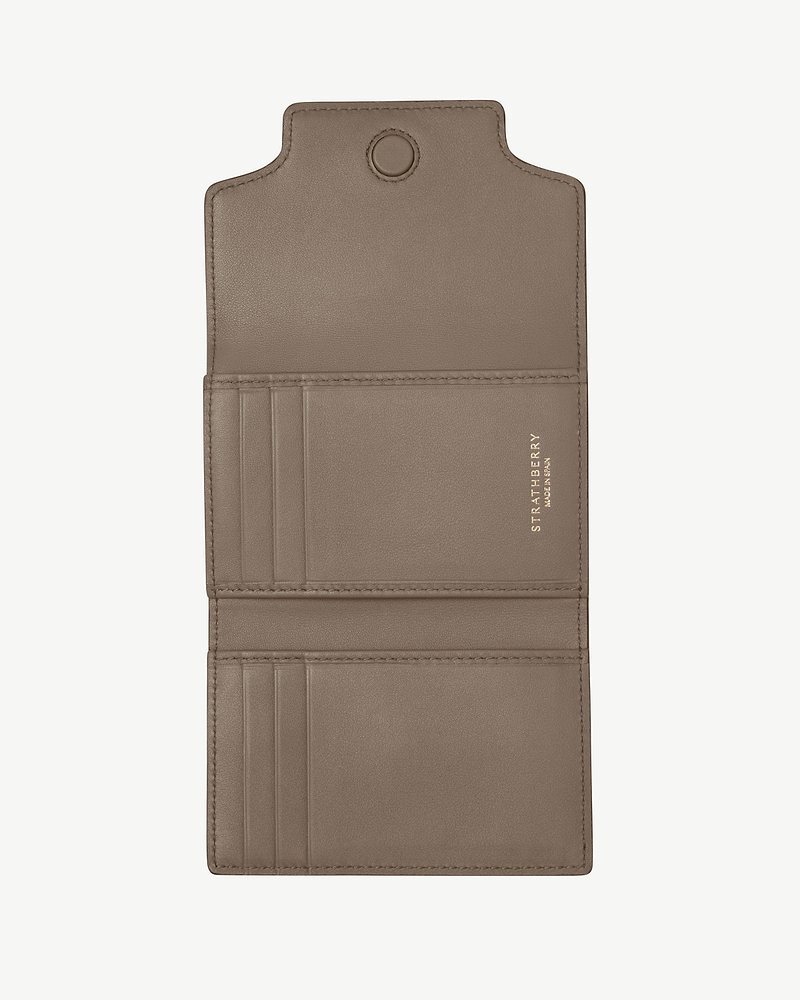 Taupe Strathberry Multrees trifold wallet open, showing card slots and compartments.